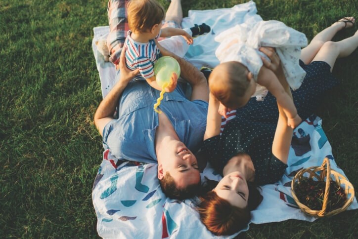 Family laying in grass | The Grove Frisco Neighborhood