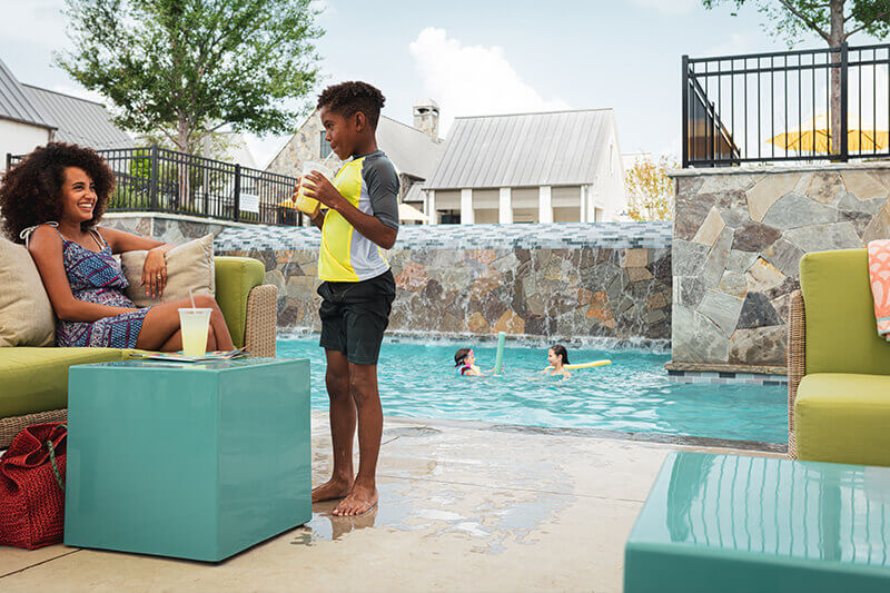 Family enjoying the swimming pool at The Grove Frisco community
