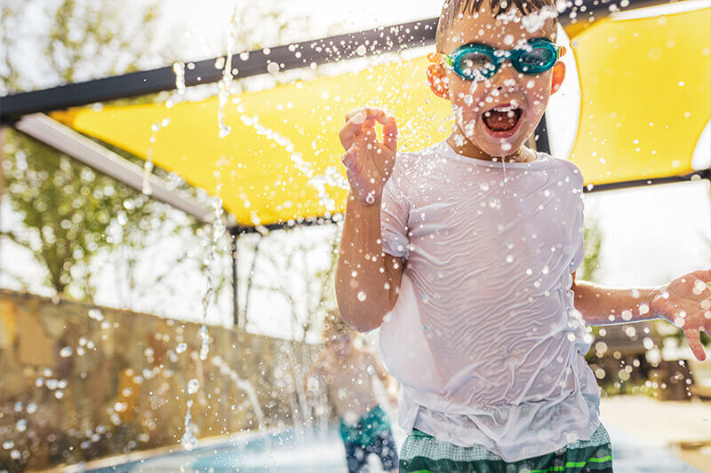 Boy playing in splash pad at The Grove Frisco community