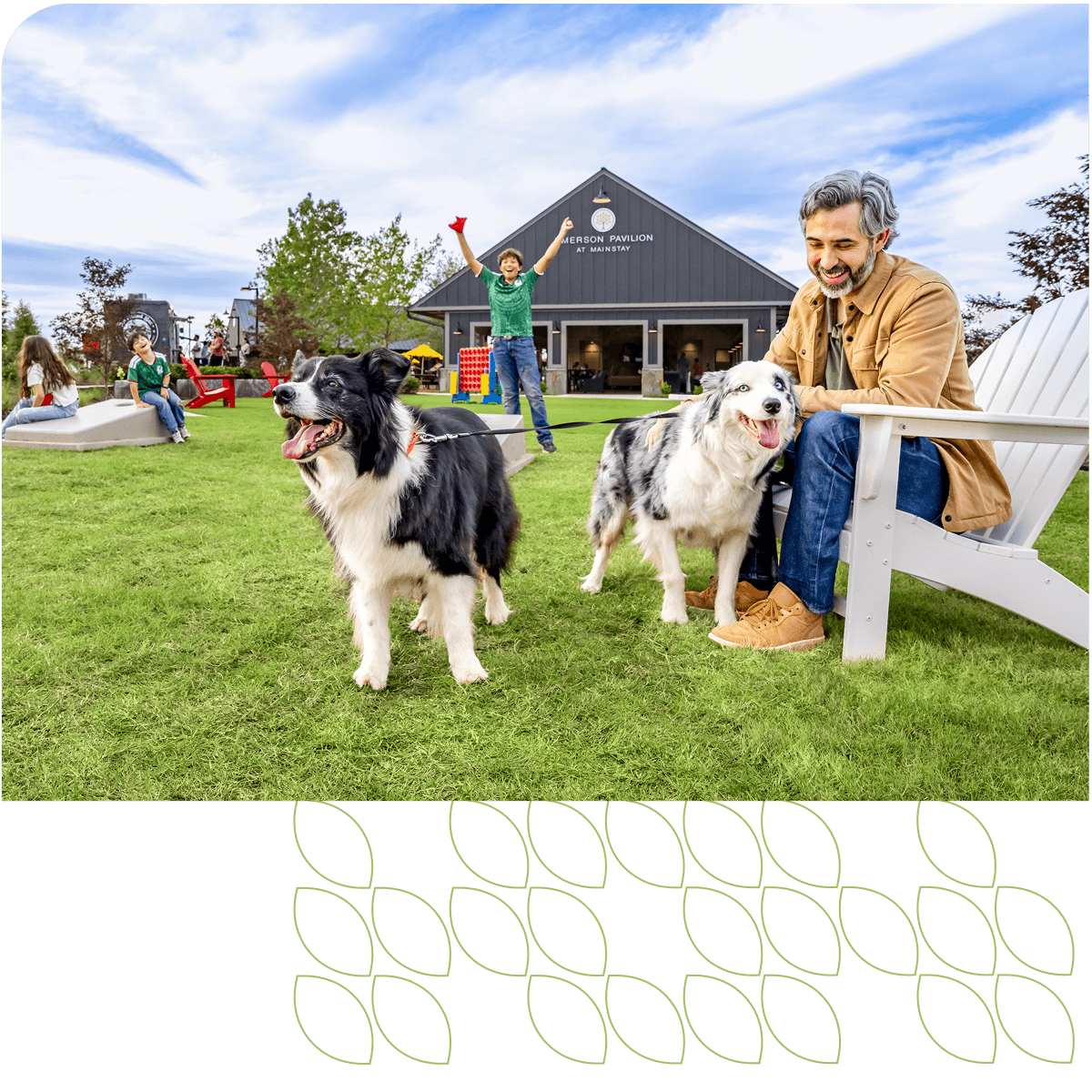man sitting in park with dogs