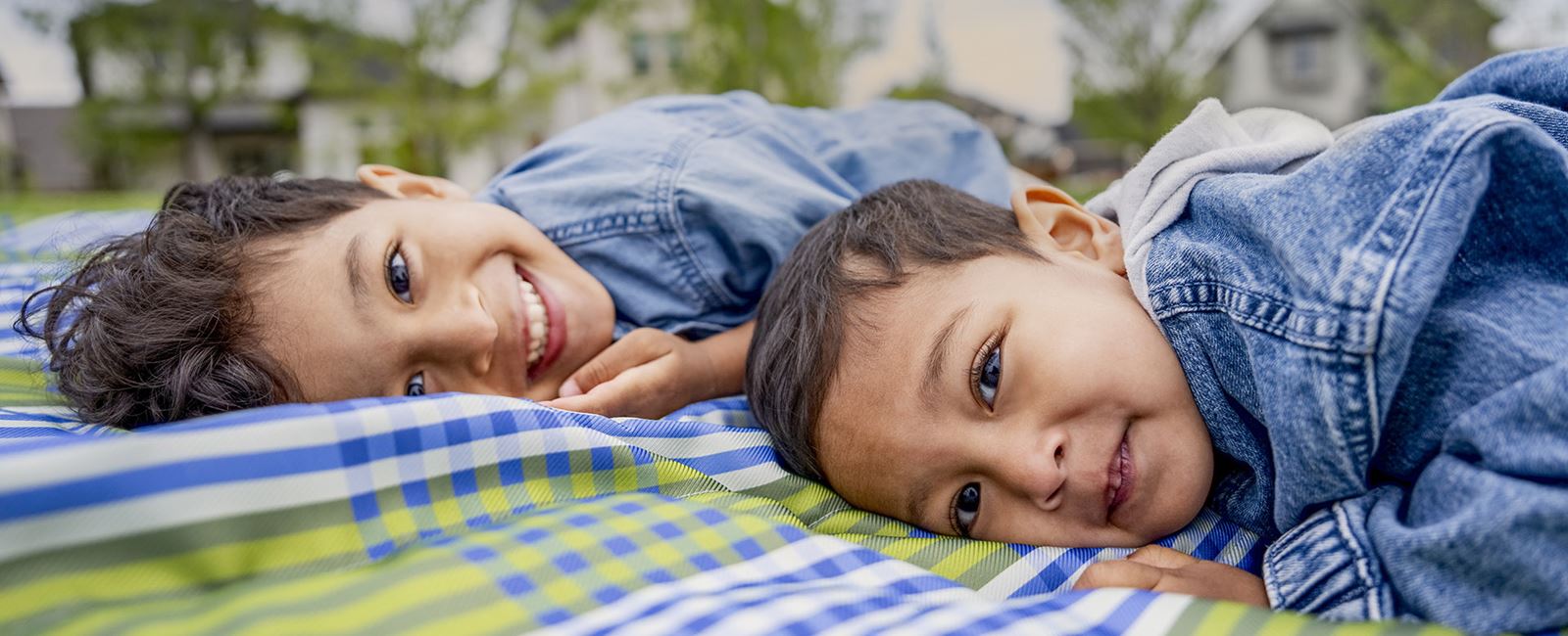 Two Kids Laying In The Grass