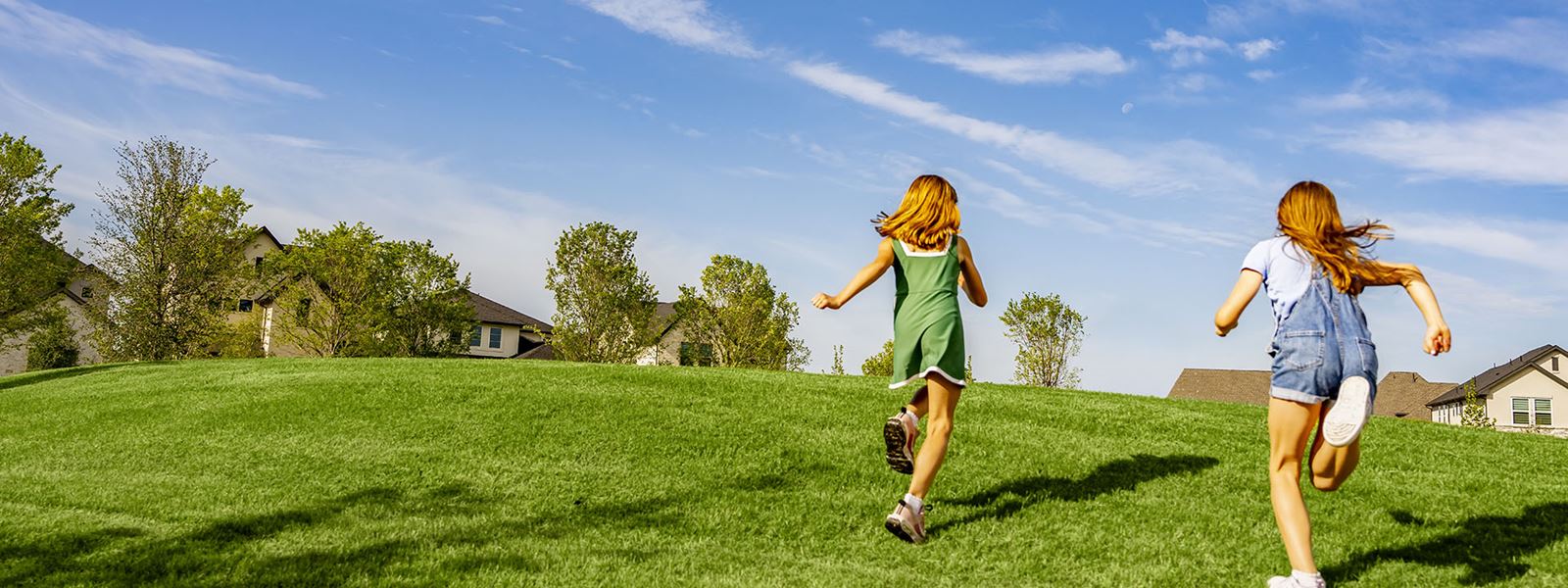 Two Girls Running Through Park